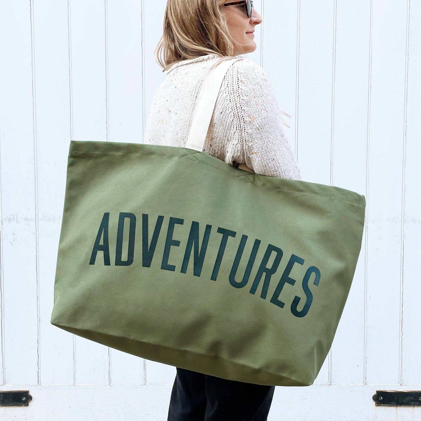 Olive green oversized canvas tote bag with "ADVENTURES" text, ideal for travel and outdoor activities.