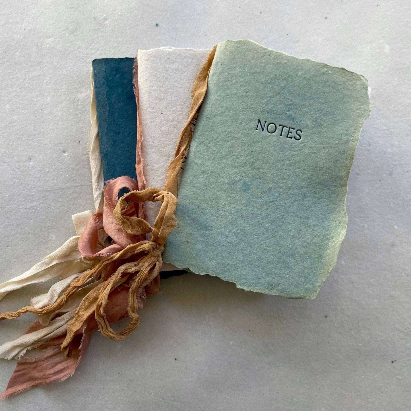 Artisan made small notebook with handmade paper and silk ribbon.