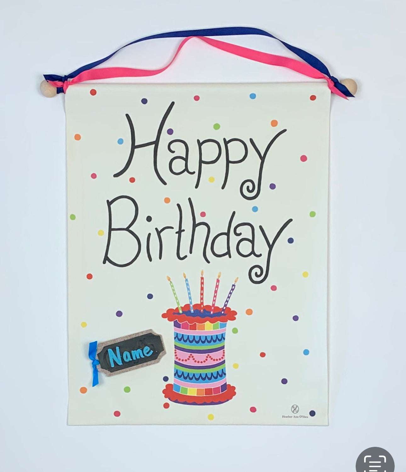 Birthday banner with colorful cake design and "Happy Birthday" text, featuring dark pink and navy ribbons for hanging.