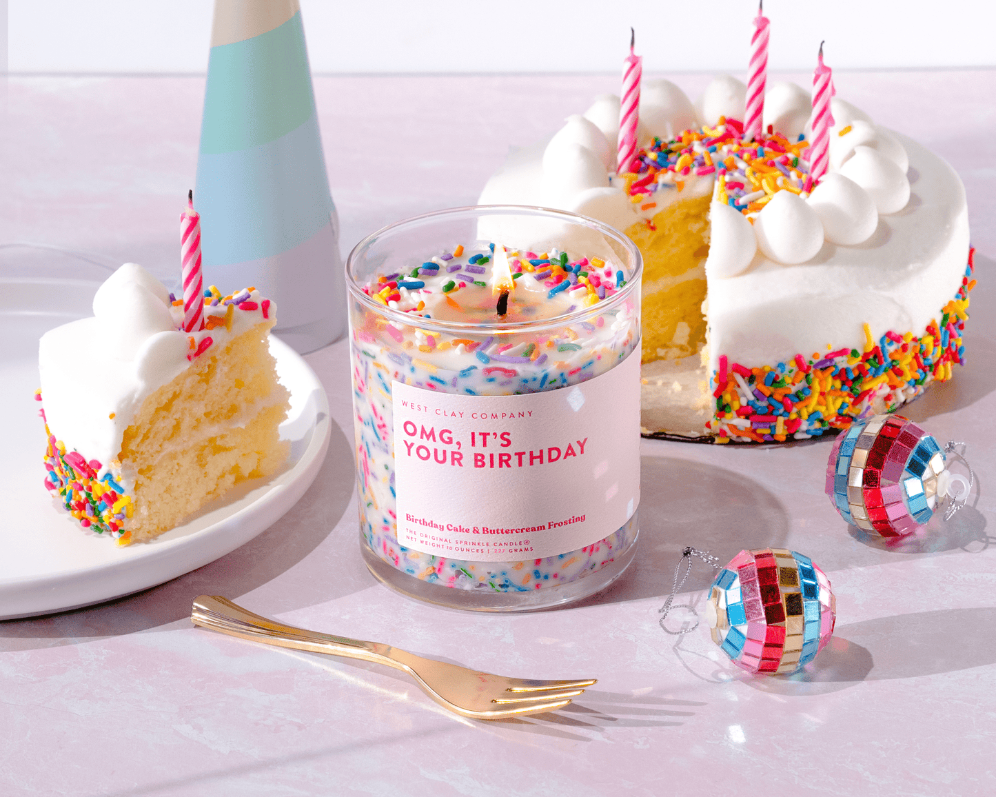 Birthday Sprinkle Candle with vanilla buttercream scent and rainbow sprinkles in a glass vessel, surrounded by festive cake and decorations.