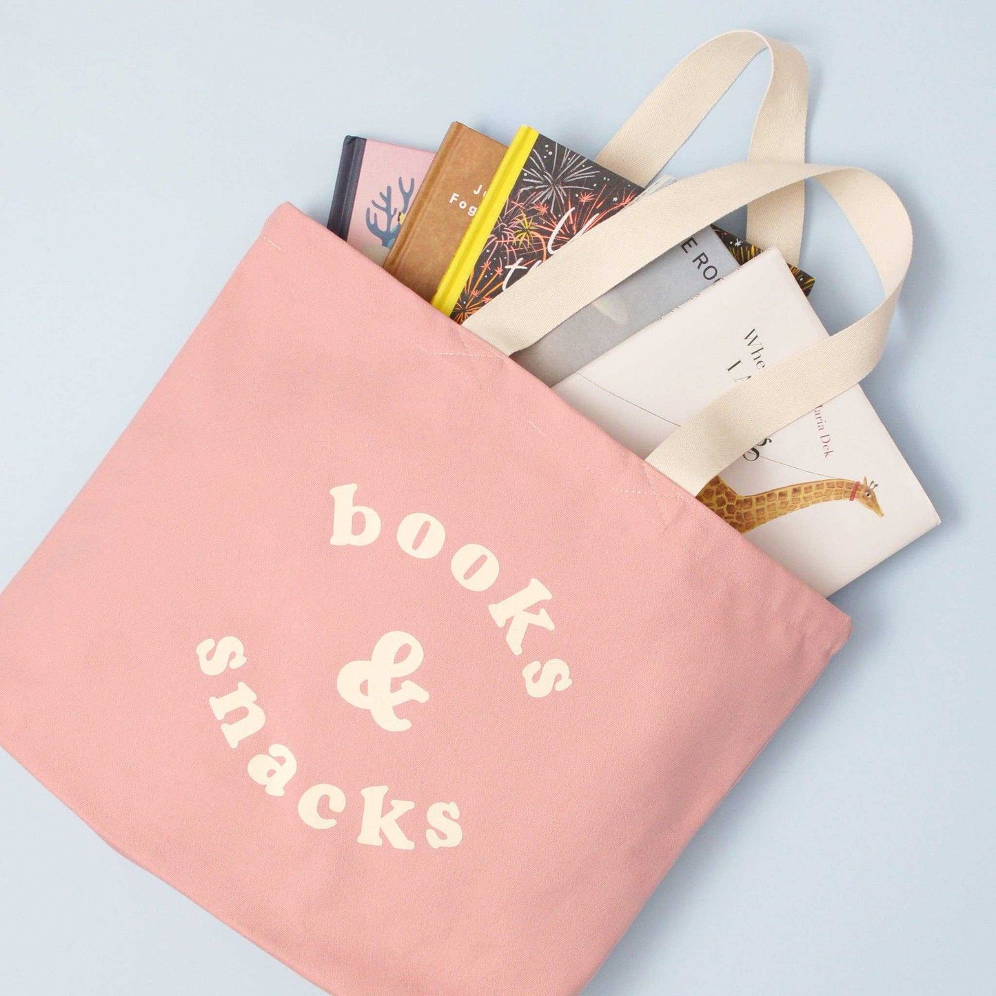 Blush pink canvas tote bag with "Books & Snacks" design, sturdy and spacious for everyday essentials.