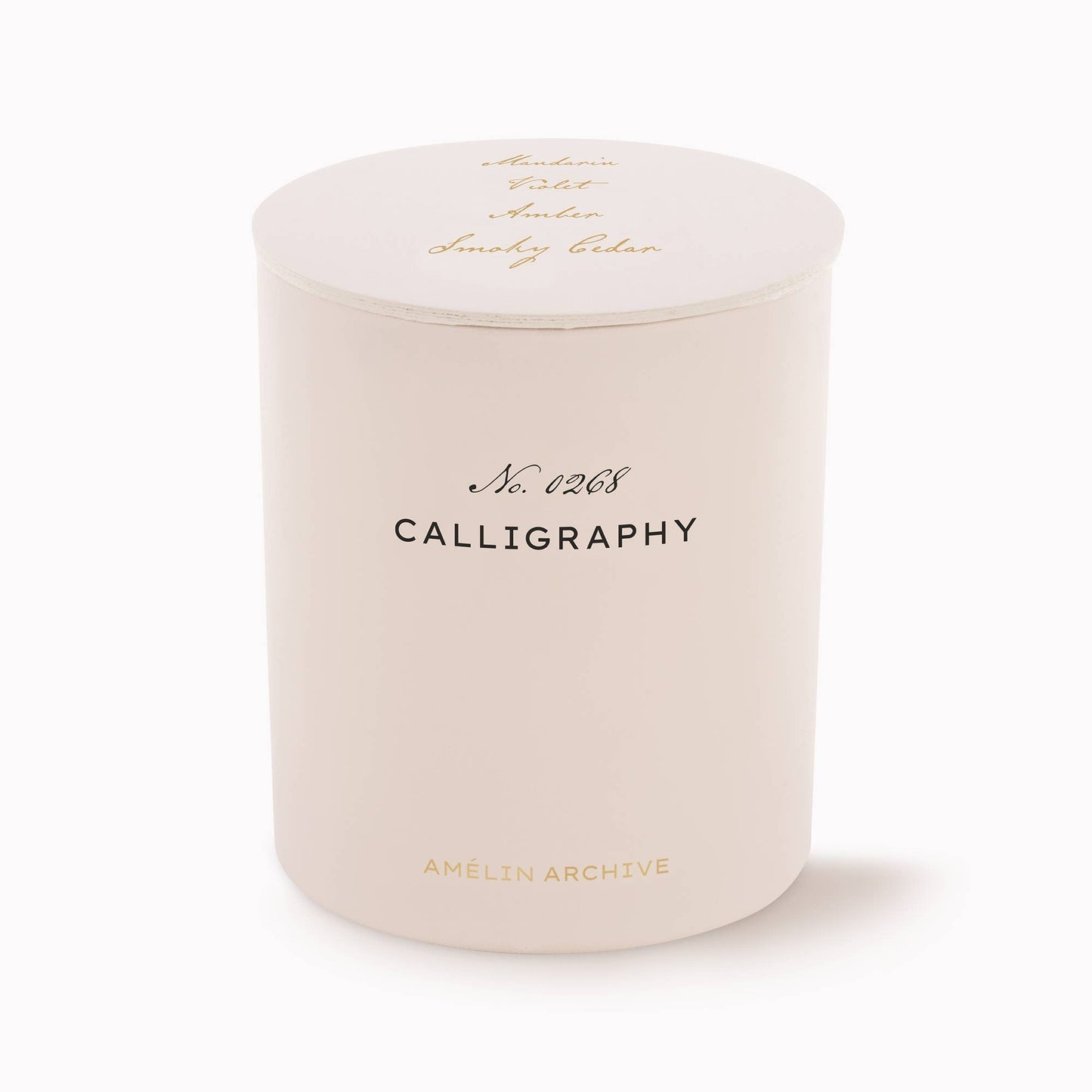 Cream glass candle with "Calligraphy" label, evoking vintage elegance and featuring Green Mandarin, Sweet Violet, Amber, and Smokey Cedar scents.