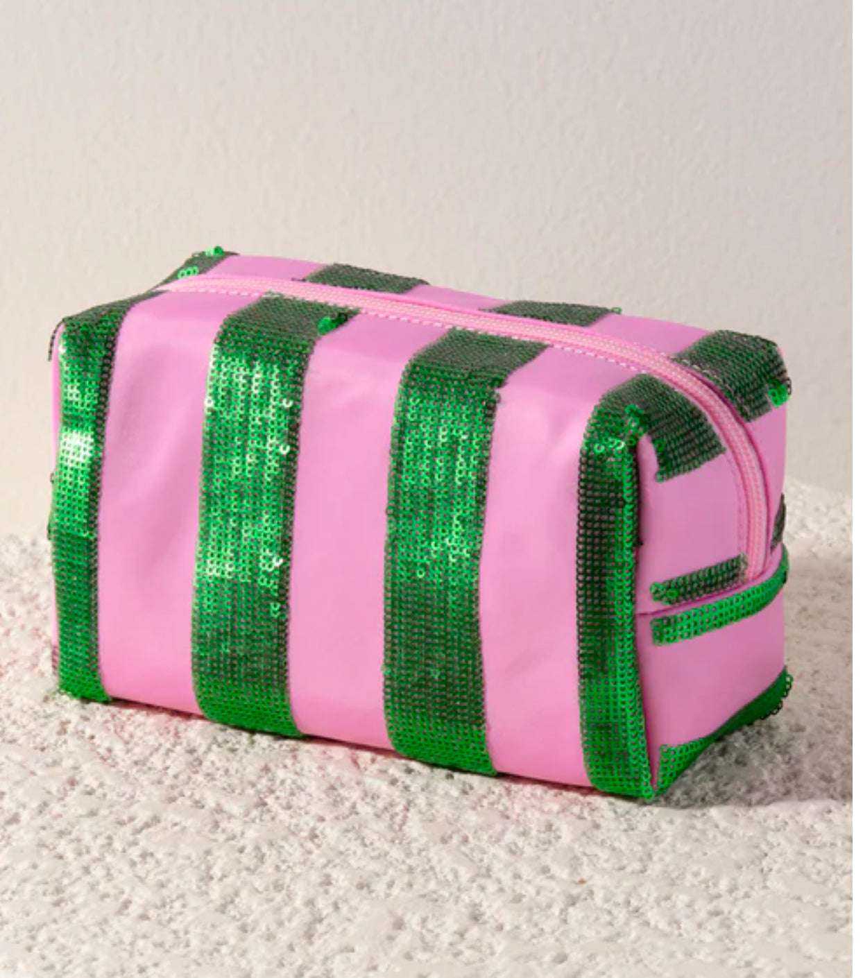 Cara Pink & Green Glimmer Stripe Pouch with zip closure on textured surface.