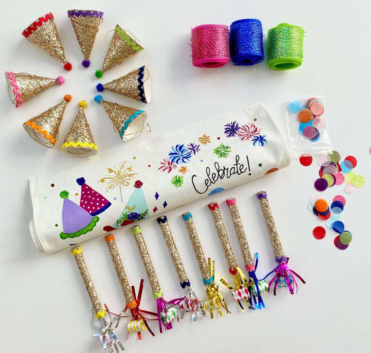 Celebration Box with table runner, fabric party hats, horns, glitter ribbon, and confetti.