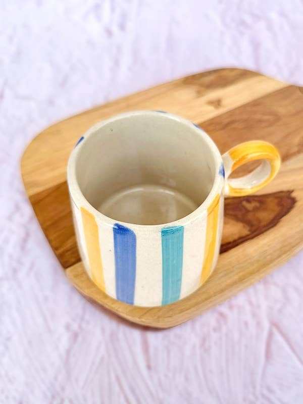 Casa Amarosa ceramic mug with bright stripes, 450ml capacity, on a wooden board.
