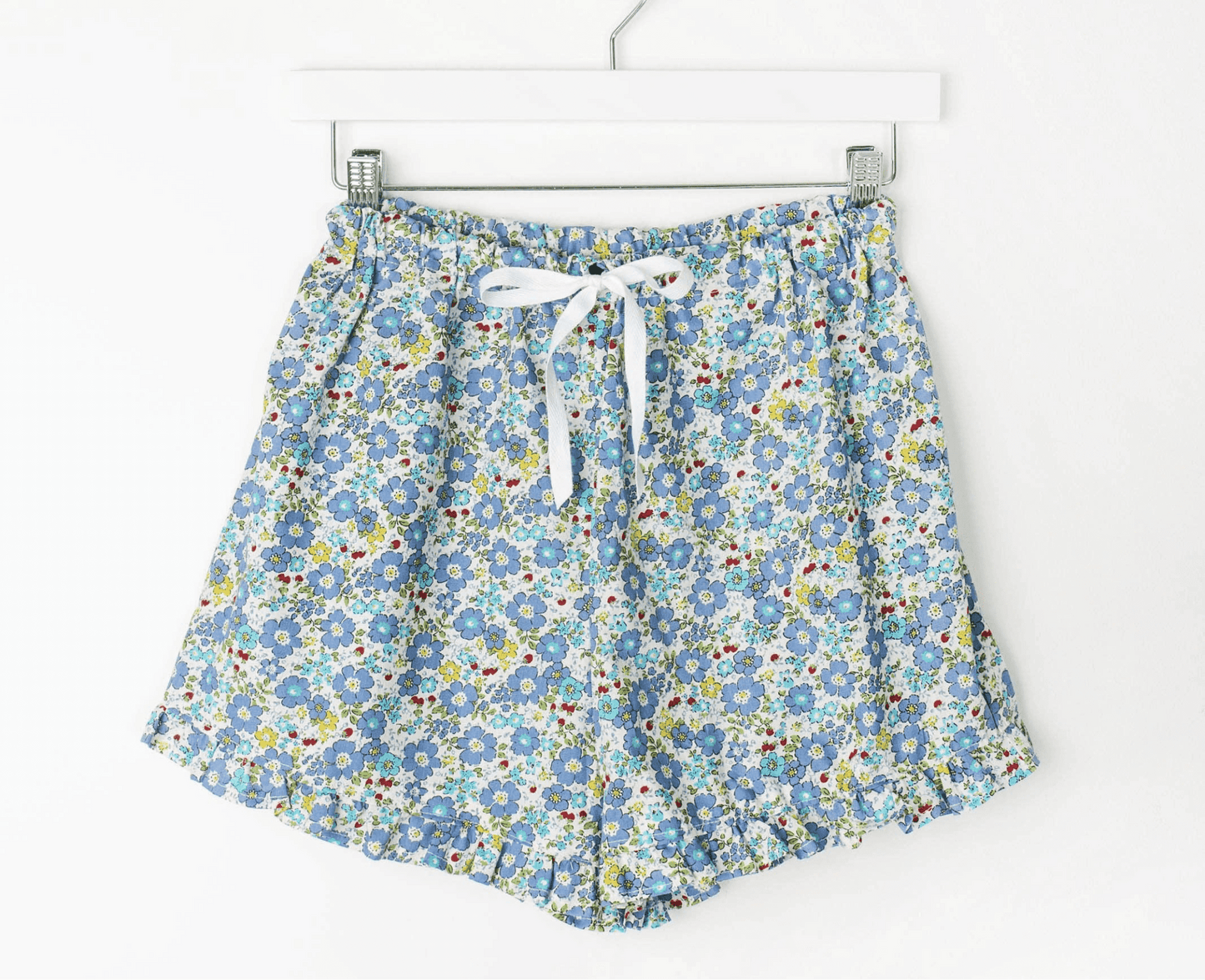 Charlotte Ruffle PJ Shorts with floral print, ruffled edges, elastic waistband, and ribbon tie.