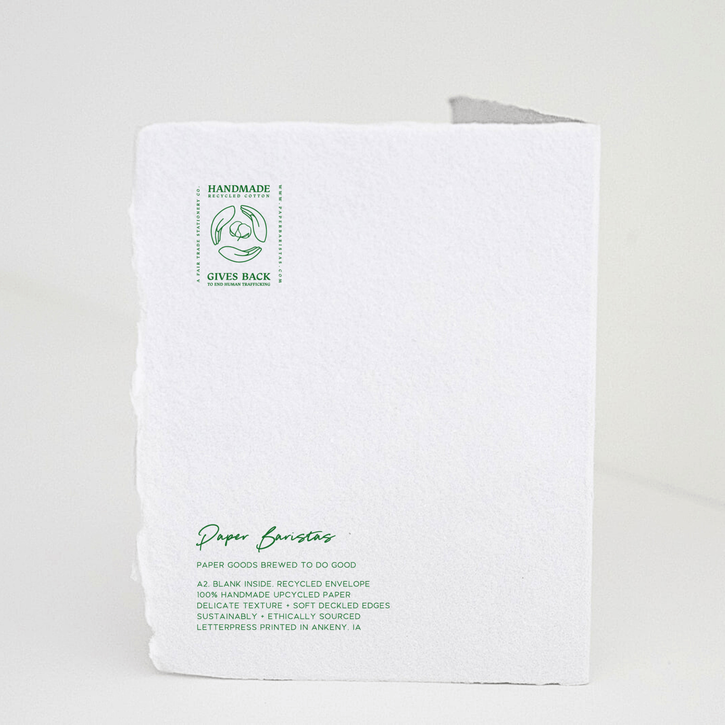 Handmade book graduation greeting card with green letterpress on white paper, decorated with eco-friendly stamps and delicate deckled edges.