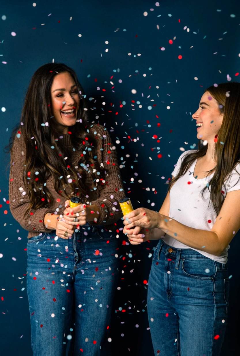 Graduates celebrating with Congrats Grad Confetti Popper releasing colorful biodegradable confetti.