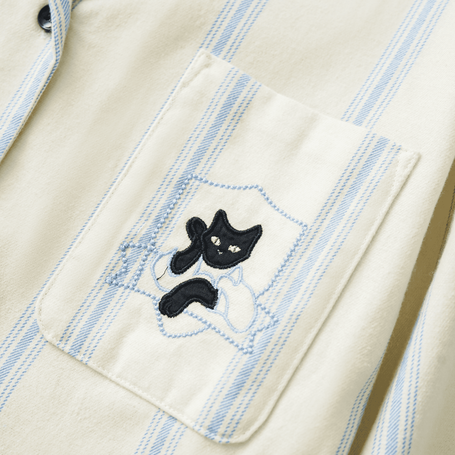 Cotton striped loungewear set with blue stripes and embroidered cat detail on cream fabric.