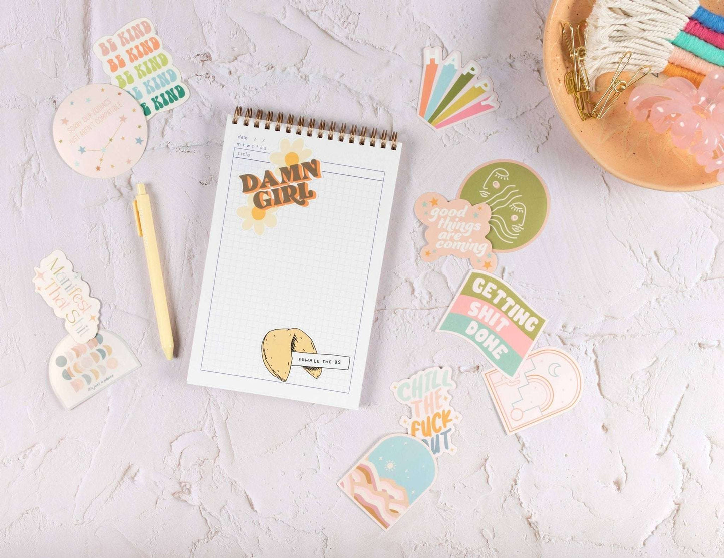 Drinking My Water Minding My Business sticker on a notebook with other decorative stickers and stationery.