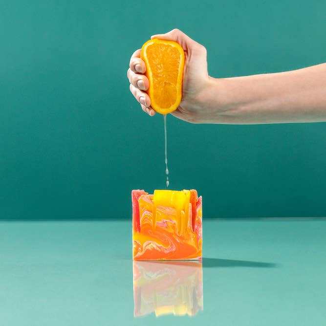 Finchberry Happy Birthday Gift Set with colorful bar soap and hand squeezing orange.