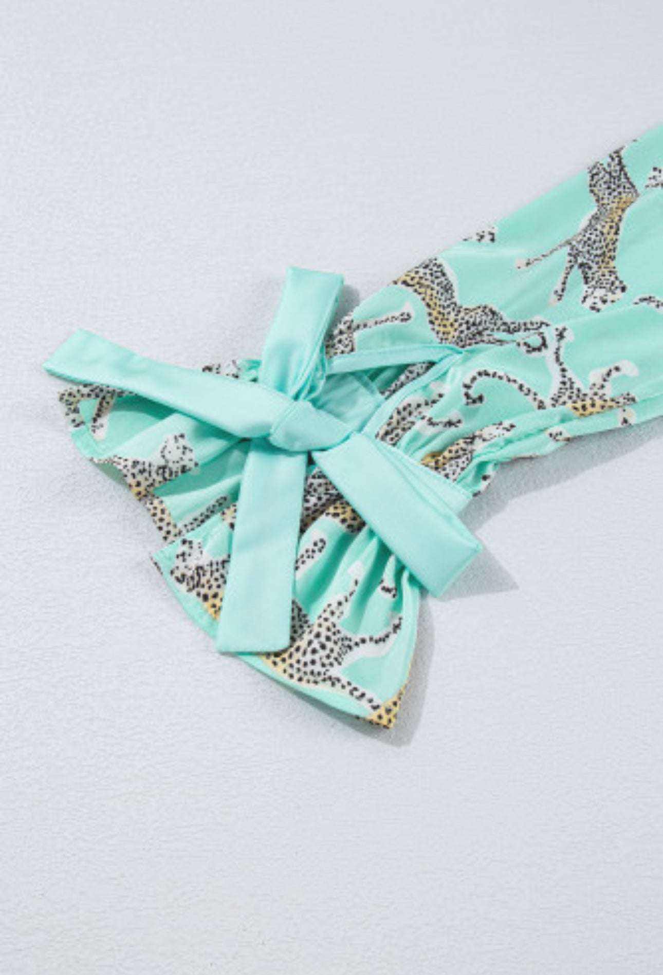 Green leopard satin fabric with ruffles and bow detail on pajama set.