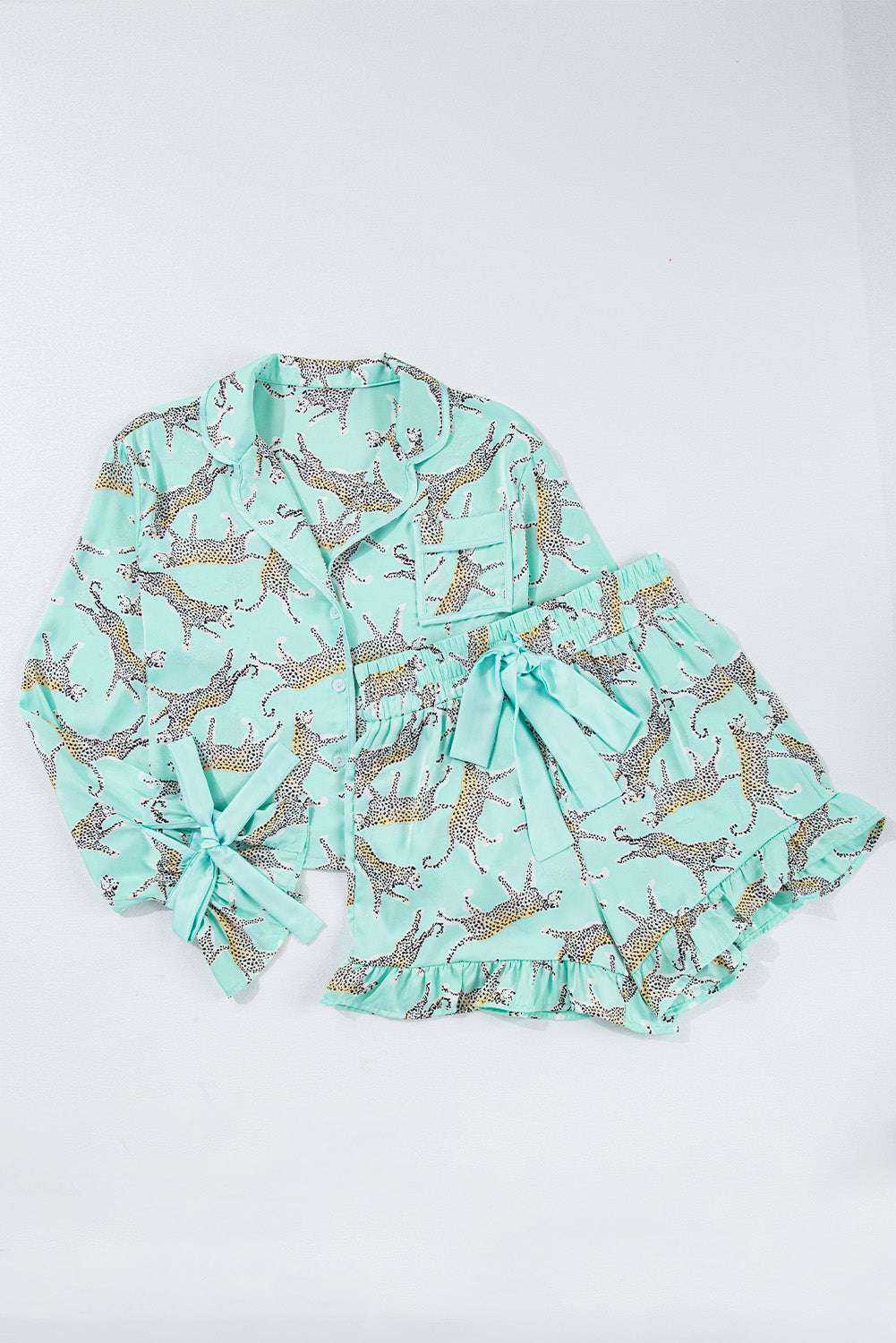Green leopard satin ruffle pajama short set with button front top and high-waisted shorts.