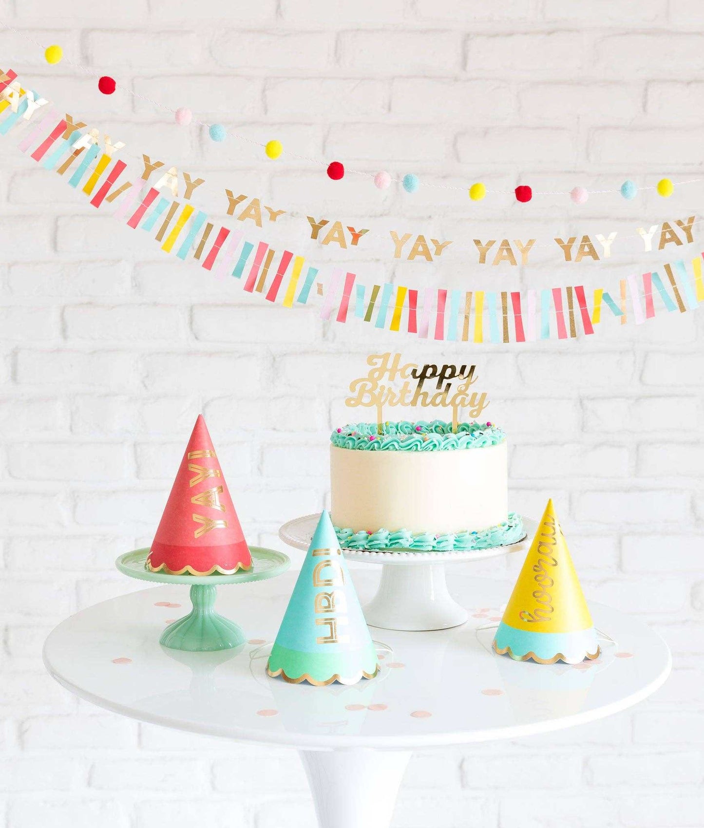 Hip Hip Hooray party hats with gold foil accents on a white table setting.