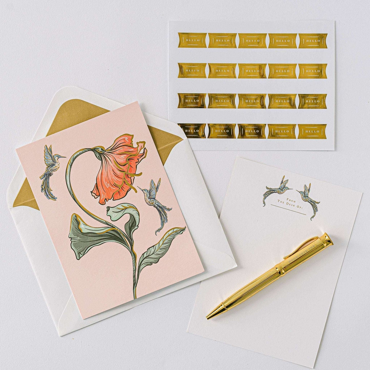 Hummingbird Luxury Stationery Set with gold foil-stamped writing sheets, metallic-lined envelopes, sealing stickers, and a gold ball-point pen.