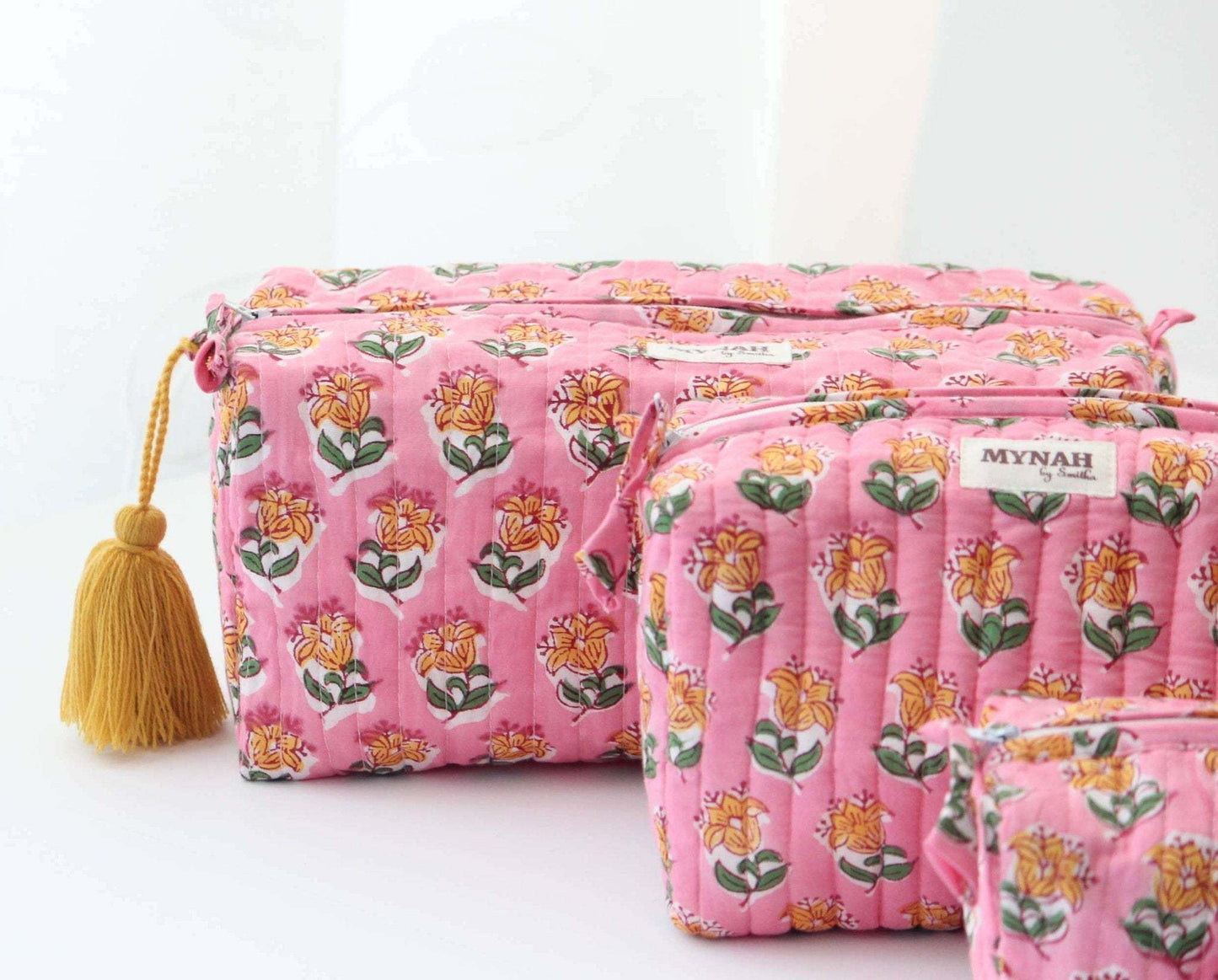 Large quilted cosmetic bag with pink bubblegum floral print and tassel.