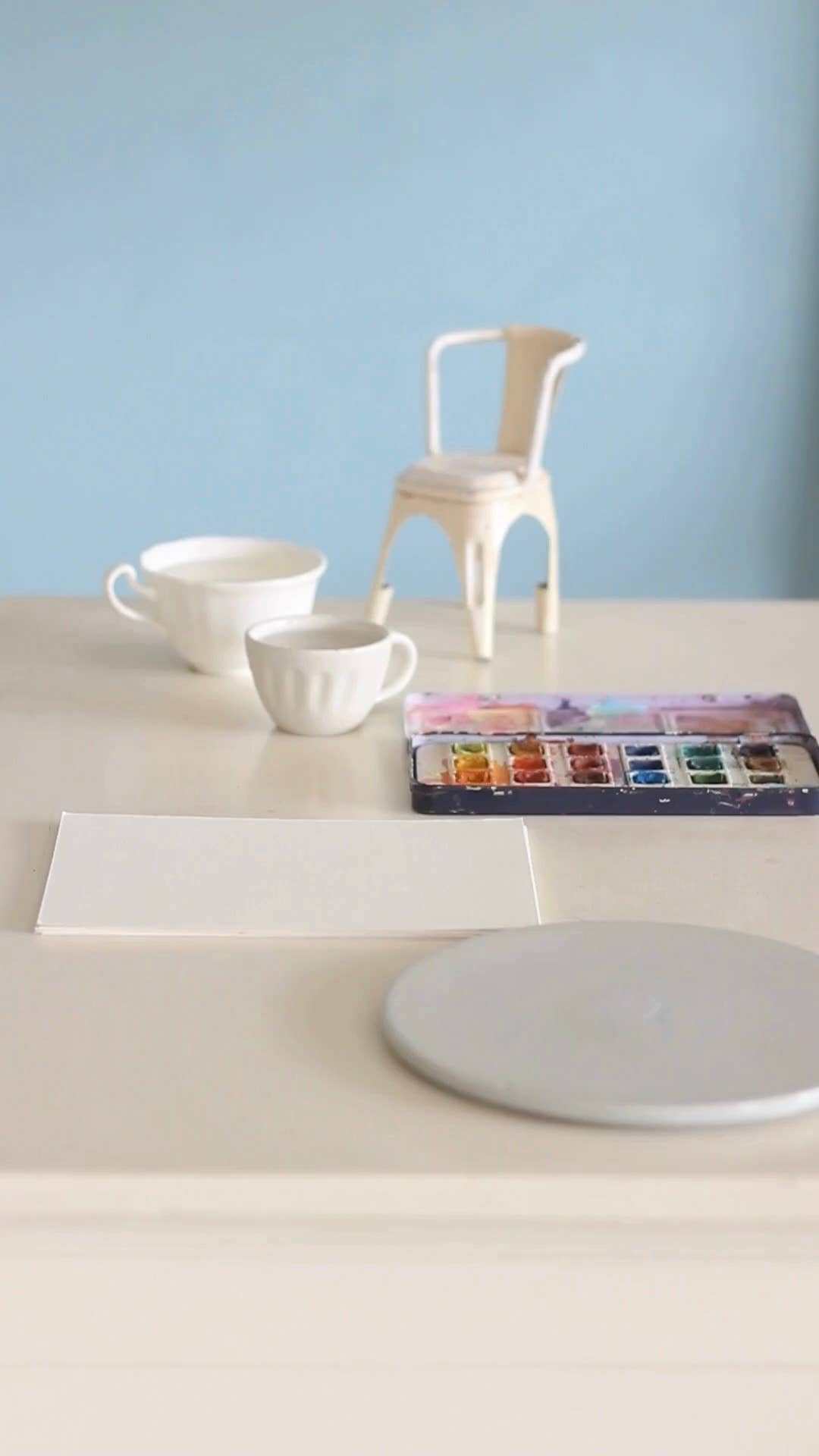 Little Hearts Measuring Ceramic Cup set with watercolor palette on table.