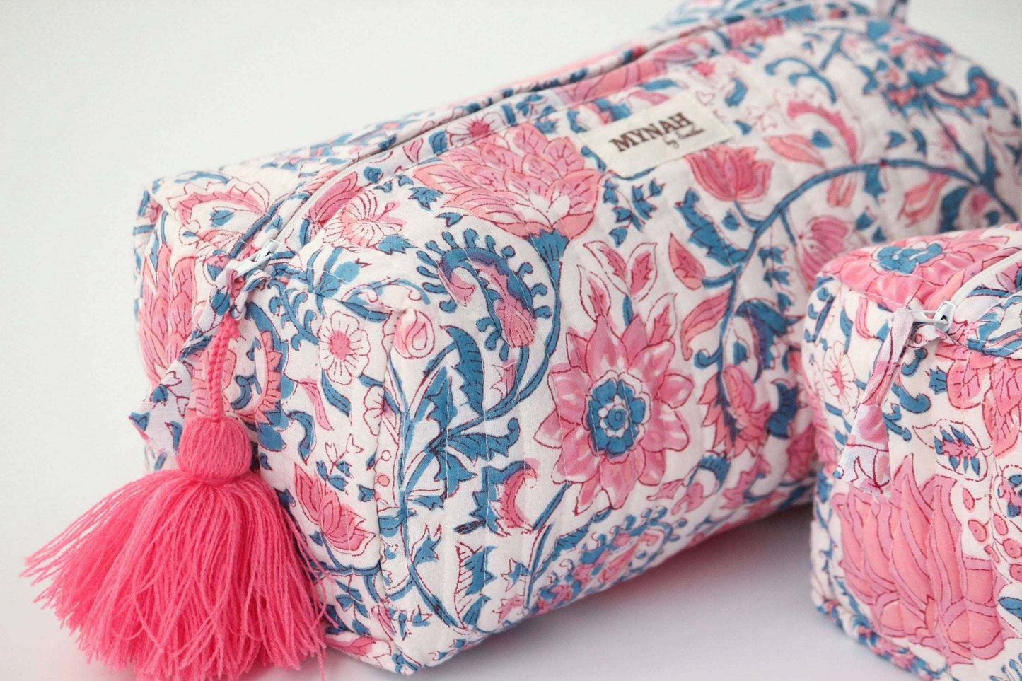 Hand block printed floral travel bag with lotus blooms, featuring waterproof lining and pink tassel.