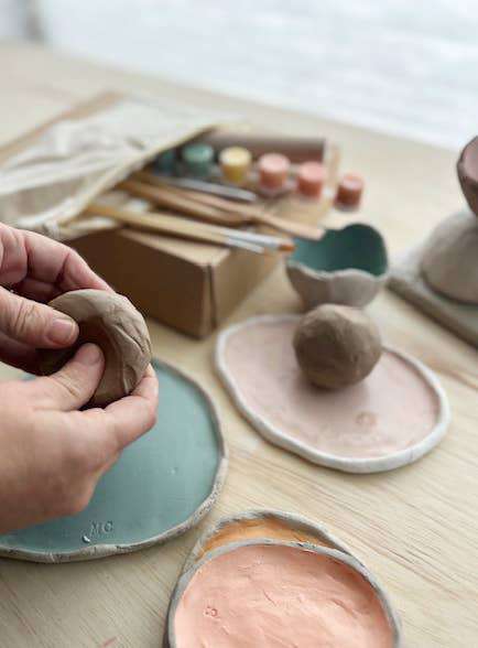 Meditative Art Clay Kit with tools, paints, and clay in use on a table.