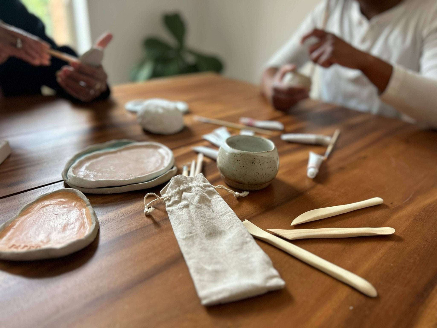 Meditative Art Clay Kit with tools and clay pieces on a wooden table, promoting creativity and connection.