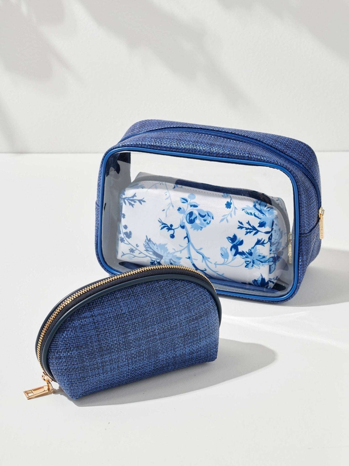 Pretty blue floral cosmetic bags set, featuring a large clear case and a smaller floral zip pouch.