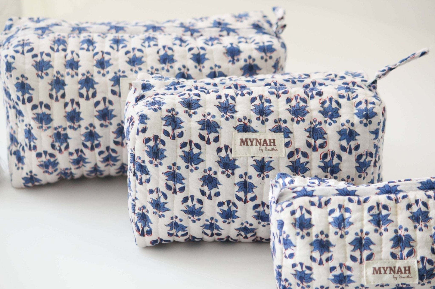 Set of 3 Blue Bonnet floral print travel bags with quilted design and waterproof lining.