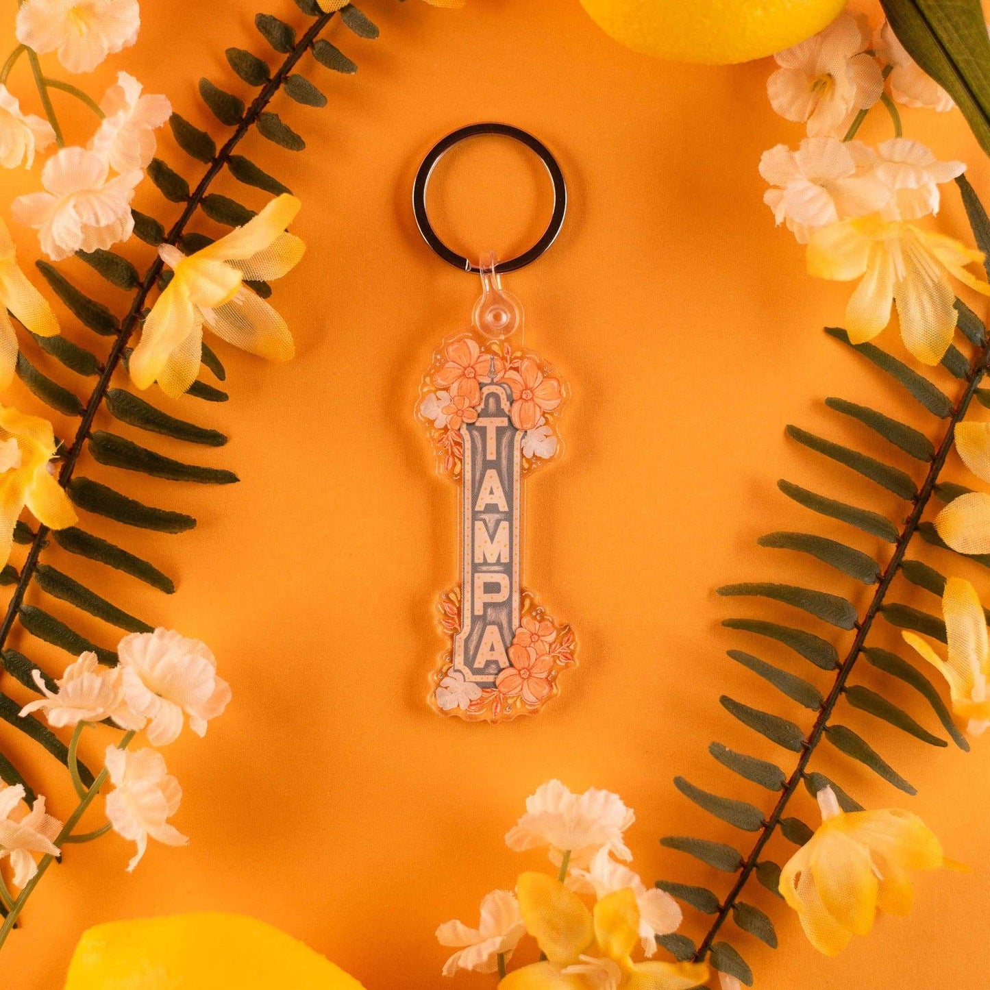 Tampa Florida keychain with hand-drawn Tampa sign on orange floral background.