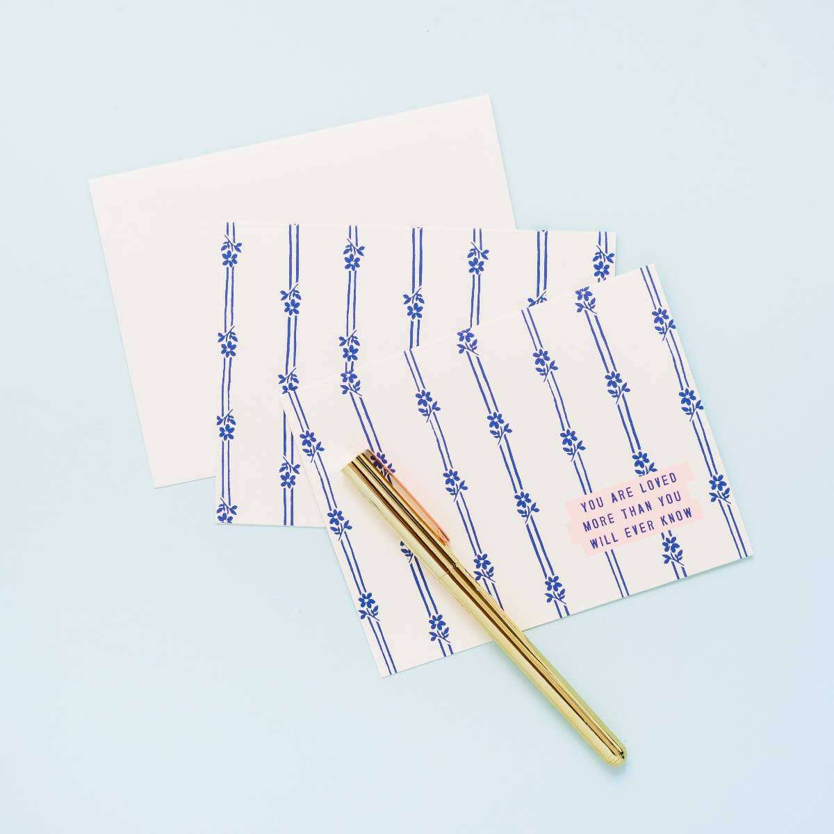 You Are Loved Daisy Greeting Card with envelope and pen, featuring blue daisy stripes on eggshell paper.