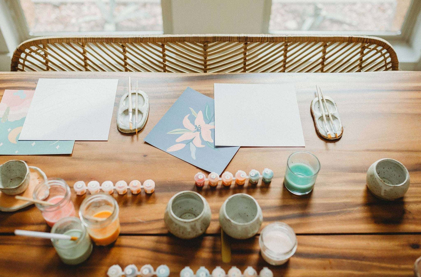 Meditative art paint by number kit featuring canvas, brushes, and acrylics on a wooden table.