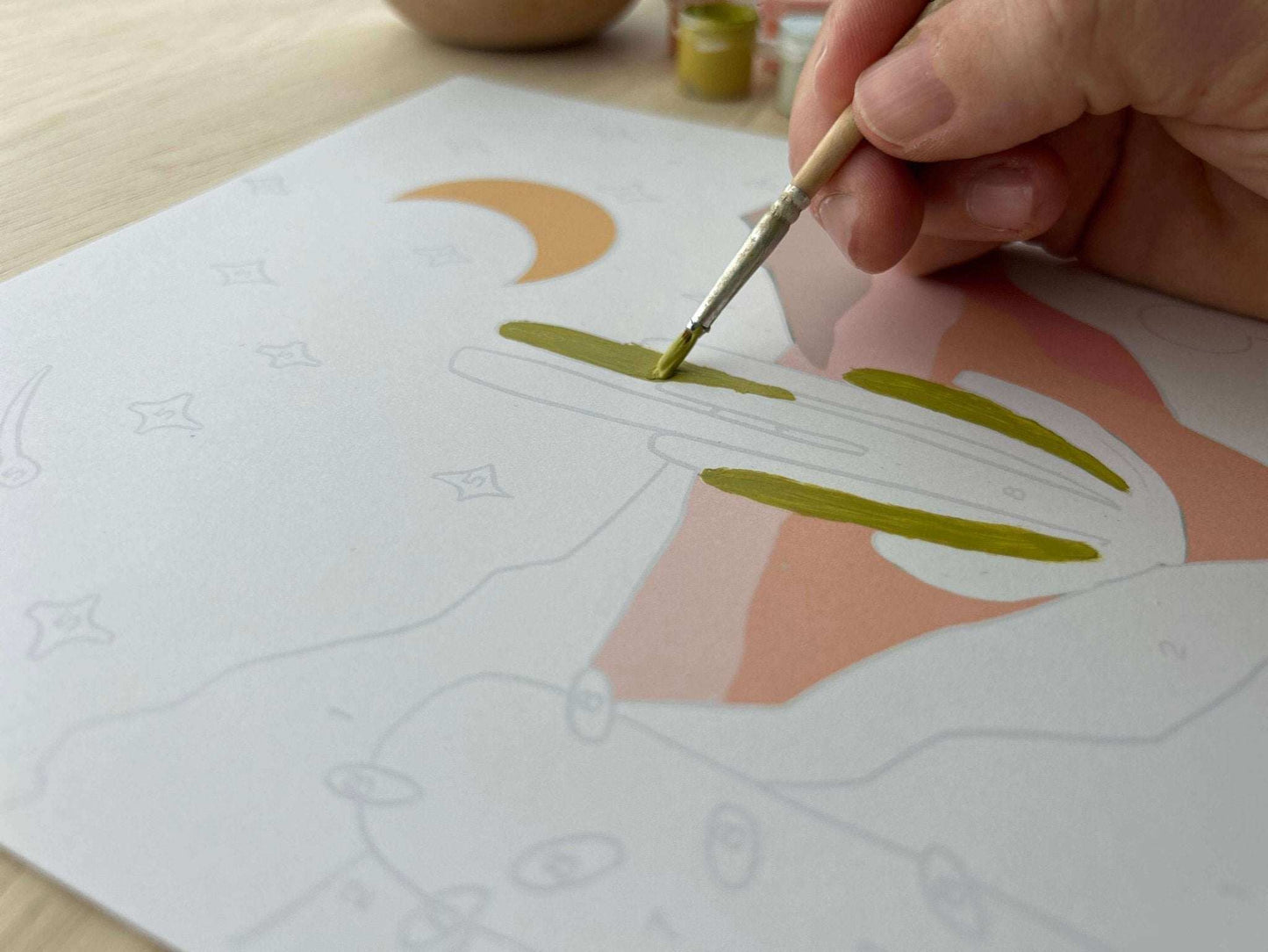 Hand painting canvas from Zen Desert Meditative Art Paint by Number Kit with easel, focusing on creative mindfulness.