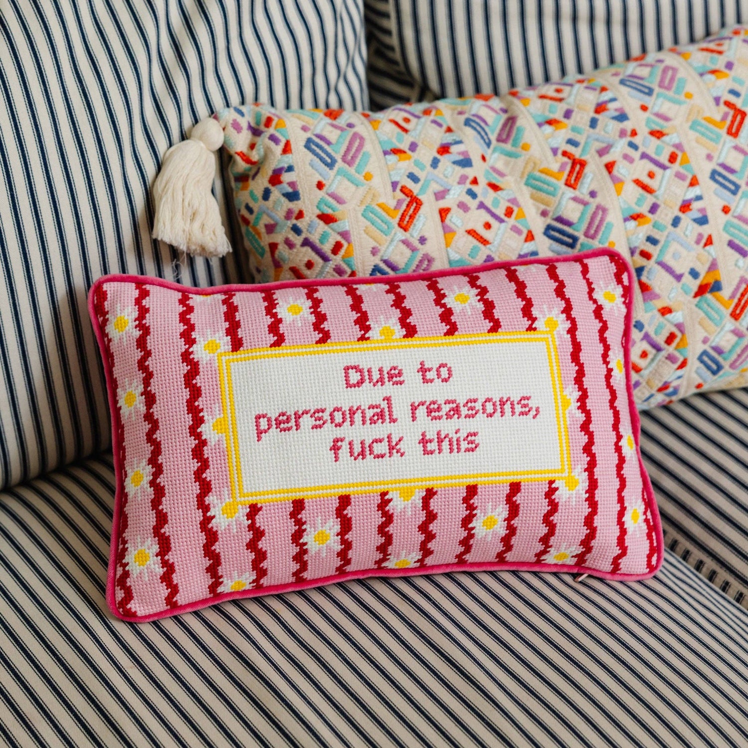 Decorative pillow with text on a striped couch
