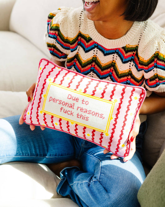 Person holding a pillow with text and colorful zigzag pattern