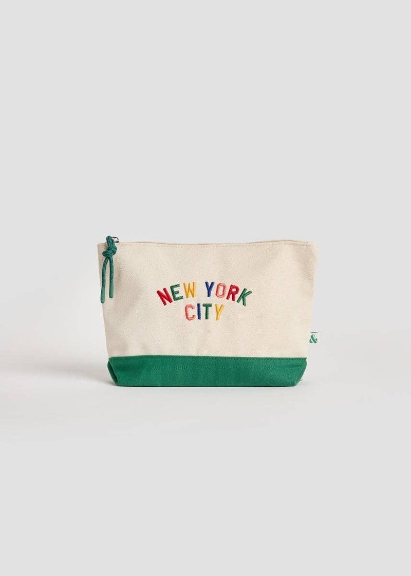 A canvas zip pouch with an off-white top and a green bottom base, featuring the text 'NEW YORK CITY' in multicolored letters and a green zipper pull, set against a light gray background.