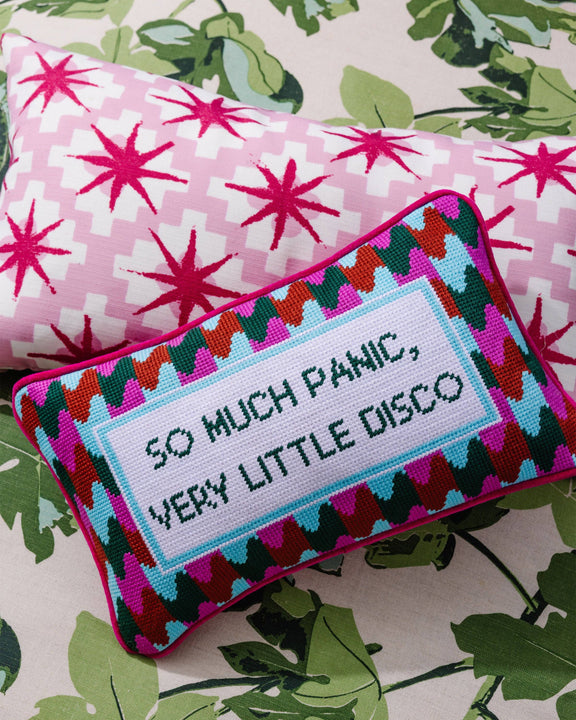 Decorative pillow with colorful geometric pattern and text on a floral background