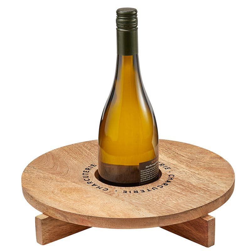Santa Barbara Design Studio charcuterie board with wine holder featuring a wine bottle in the center of a mango wood board.