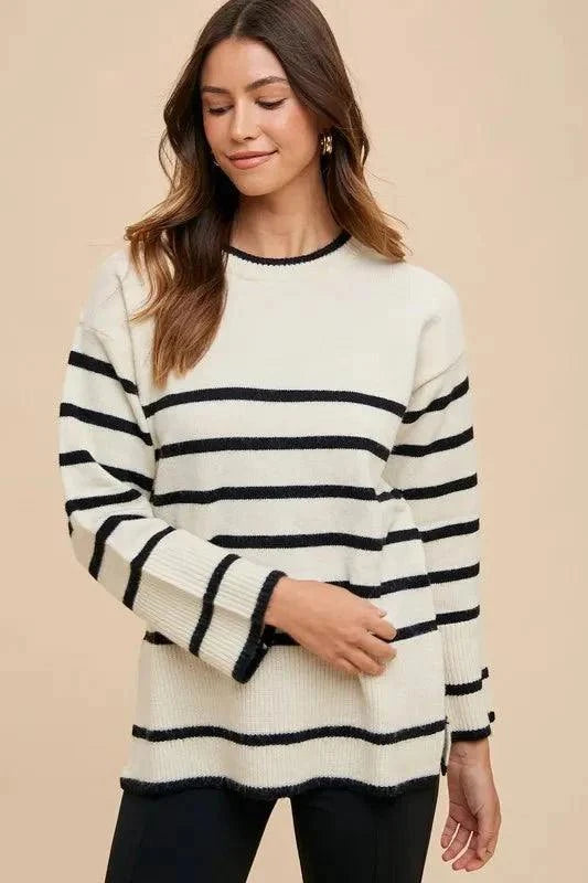 Side slit striped round neck sweater with black and white stripes.