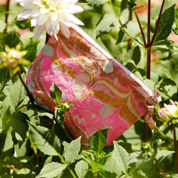 Astral Marbled Pouch Sailors Delight in garden setting with pink, gold, and blue marbled design.