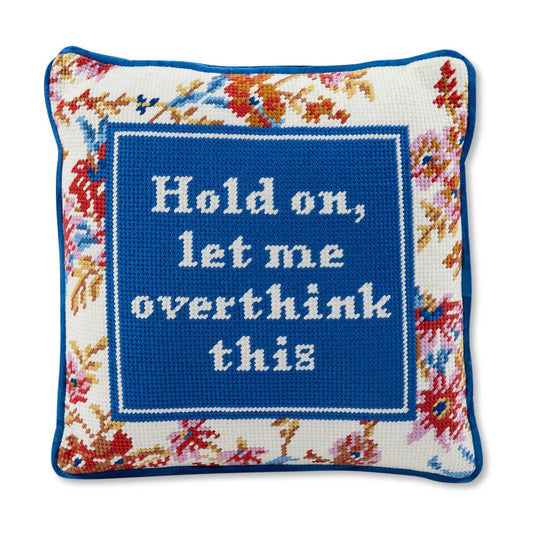 Decorative pillow with floral border and text 'Hold on, let me overthink this' in the center.