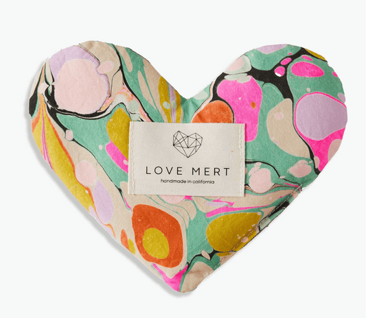 Heart-shaped eye pillow with colorful marbled pattern, made from organic cotton and raw silk, filled with flaxseed and lavender for relaxation.