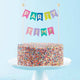 Garland Cake Topper on colorful sprinkle cake.