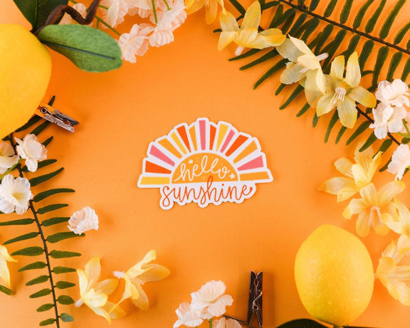 Hello Sunshine Sticker with colorful sunburst design surrounded by flowers and lemons.