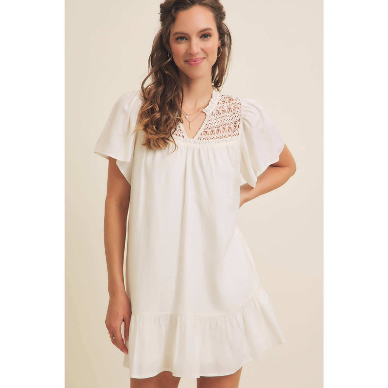Crochet mini dress with split neck, flare sleeves, ruffled hem, and crochet yoke.