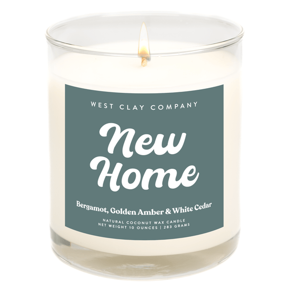 New Home Candle with Bergamot, Amber, and White Cedar scent in a glass jar.