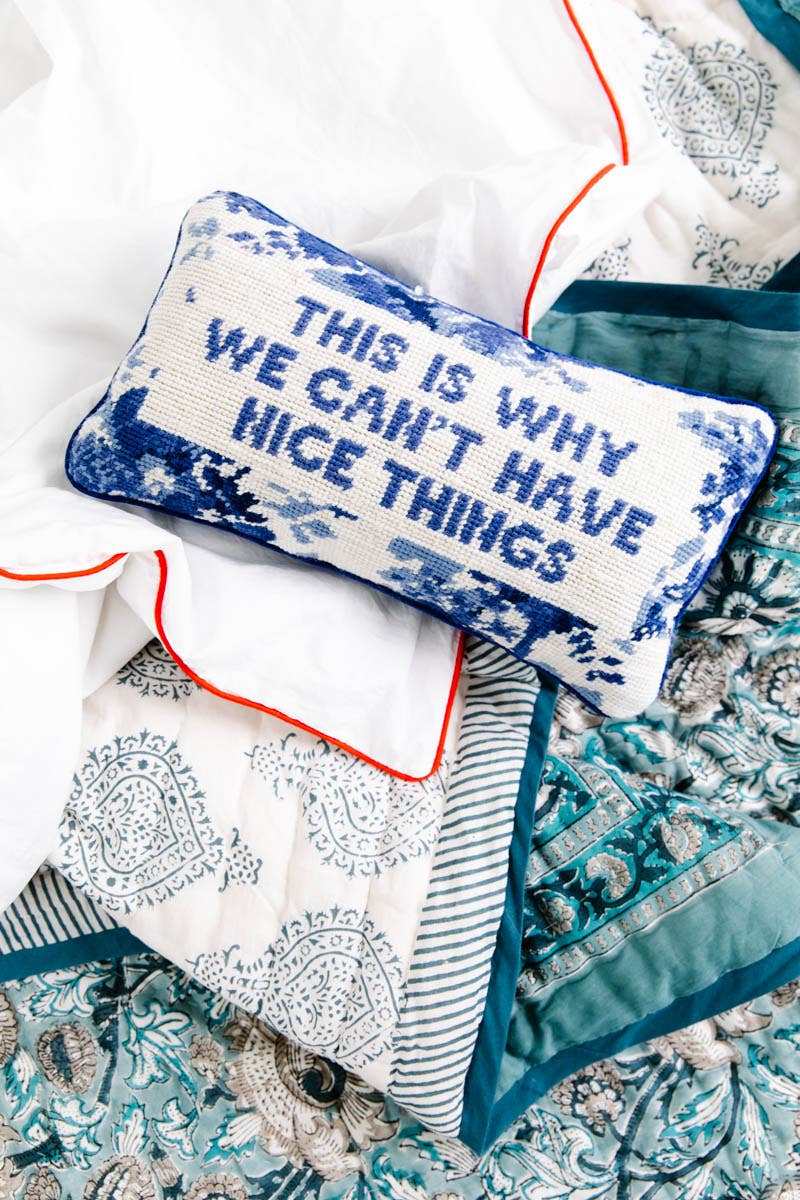 Nice Things Needlepoint Pillow with humorous slogan, embroidered in wool, backed with blue velvet, 8"x14", decorative and gift-ready.
