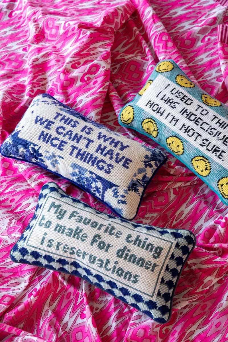 Chic needlepoint pillow with humorous slogan and blue velvet backing.