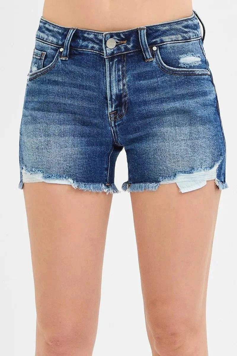 Denim low-rise shorts with distressed details and raw frayed hem.