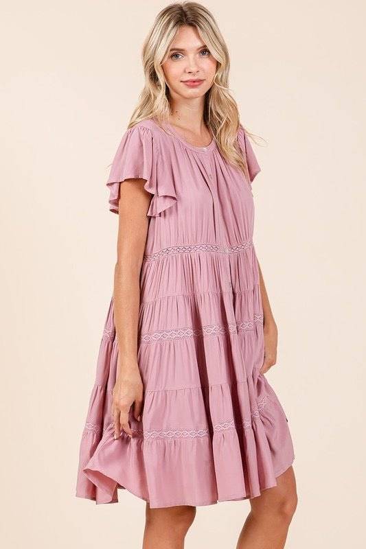 Lace detail ruffled button down tiered dress in pink worn by a model.