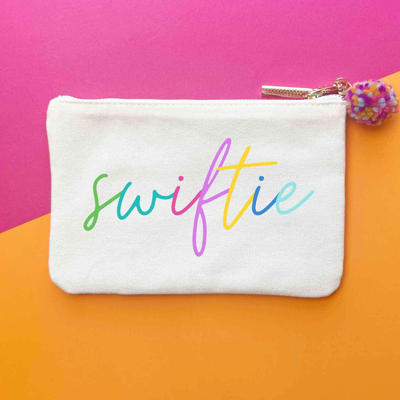 Swiftie Colorblock Script Bag with colorful script and pom keychain on canvas.