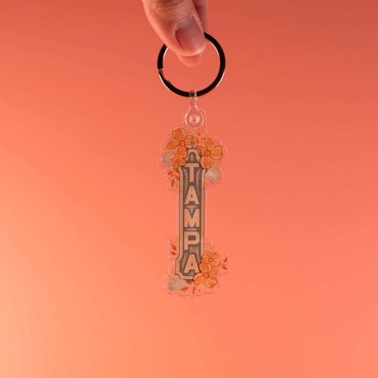 Acrylic Tampa Florida keychain with hand-drawn theater sign design against orange background.