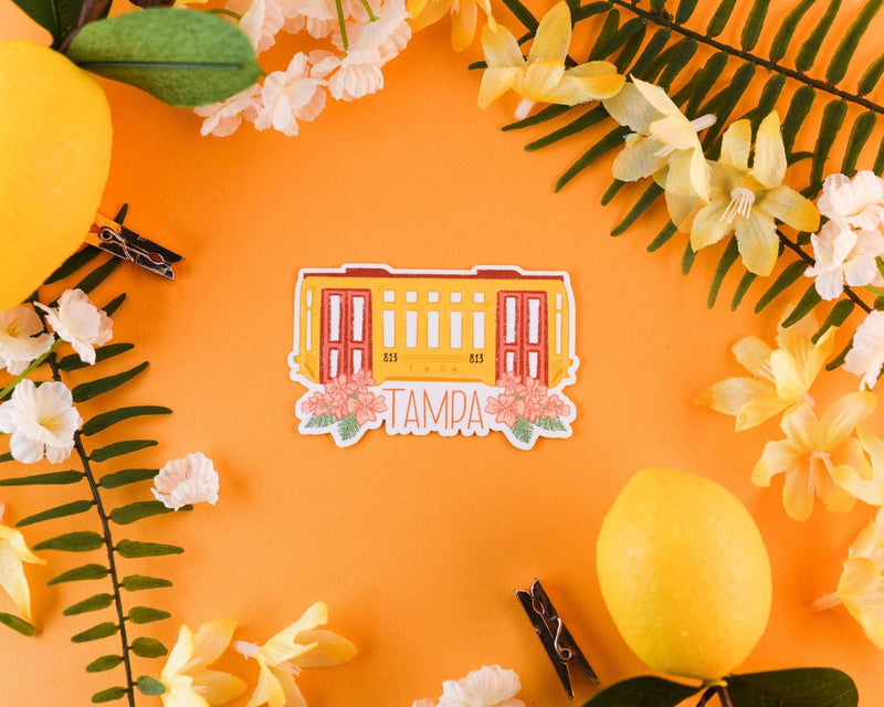 Tampa Trolly Sticker with floral accents on orange background.